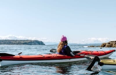 A person kayaking in Secret Cove in Halfmoon Bay on the Sunshine Coast